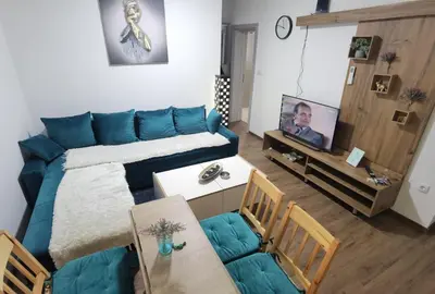 a living room with a blue couch and a television at Apartman VRH in Vrnjačka Banja