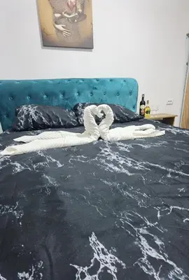 a bed with a black and white comforter at Apartman VRH in Vrnjačka Banja
