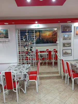 a dining room with white tables and red chairs at Marko Konak in Niš