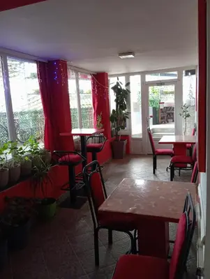 a restaurant with tables and chairs and windows at Marko Konak in Niš