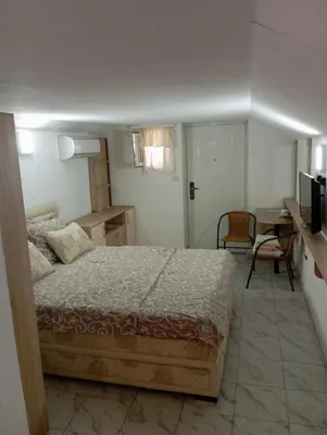 a bedroom with a bed and a desk and a table at Marko Konak in Niš