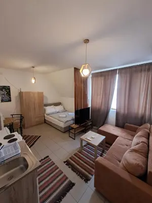a living room with a couch and a bed at Sofi III in Niš