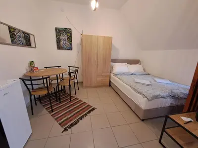 a bedroom with a bed and a table with chairs at Sofi III in Niš