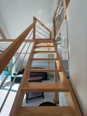 a staircase in a house with wooden rails at Apartman TERASA in Beljevina