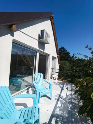 two blue chairs sitting on a patio next to a house at Apartman TERASA in Beljevina