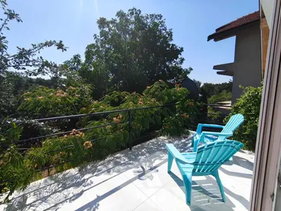 two blue chairs sitting on a porch at Apartman TERASA in Beljevina