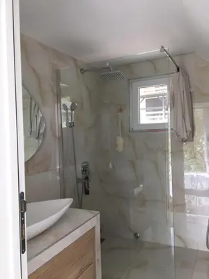 a bathroom with a glass shower and a sink at Apartman TERASA in Beljevina