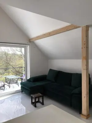 a living room with a green couch and a window at Apartman TERASA in Beljevina