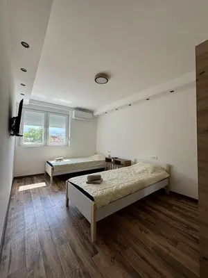 a room with two beds and a tv in it at Apartman Centar in Kuršumlija