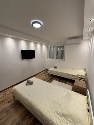 a bedroom with two beds and a flat screen tv at Apartman Centar in Kuršumlija