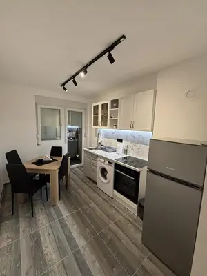 a kitchen with a table and a stove top oven at Apartman Centar in Kuršumlija
