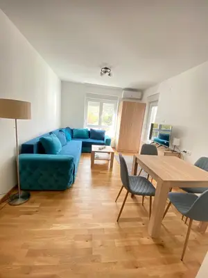 a living room with a blue couch and a table at Apartman Sky view - Sokobanja in Soko Banja