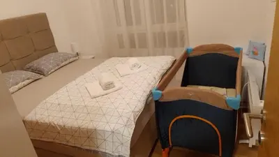 a small bedroom with a bed and two chairs at Apartman Sky view - Sokobanja in Soko Banja