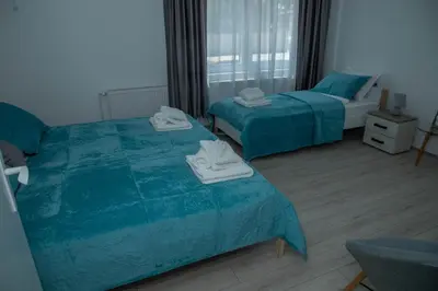 a bedroom with two beds with towels on them at Apartmani Rosica in Ribarska Banja