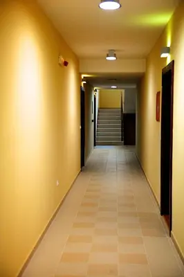 a long hallway with yellow walls and a tile floor at Apartments Villa Splendor in Vrnjačka Banja