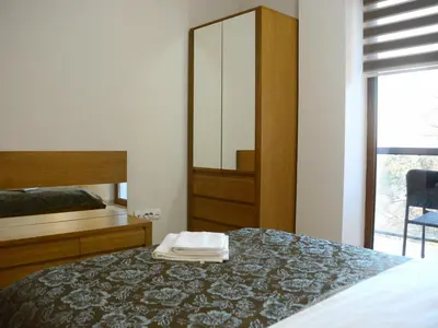 a bedroom with a bed with a dresser and a mirror at Apartments Villa Splendor in Vrnjačka Banja