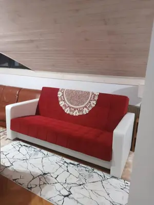 a red couch sitting in a living room at Apartmani Jelena in Vrnjačka Banja