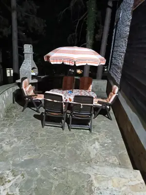 a patio with a table and chairs and an umbrella at Apartmani Jelena in Vrnjačka Banja
