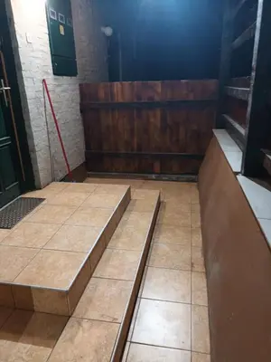 a room with wooden walls and tiled floors at Apartmani Jelena in Vrnjačka Banja
