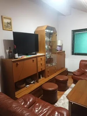 a living room with a television on a wooden entertainment center at Apartmani Jelena in Vrnjačka Banja
