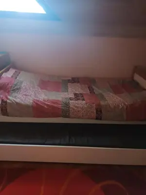 a bed with a quilt on it in a room at Apartmani Jelena in Vrnjačka Banja