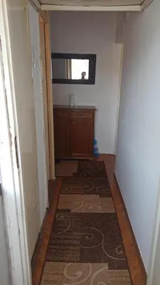 a hallway with a rug on the floor and a window at Apartman NINA in Kuršumlija