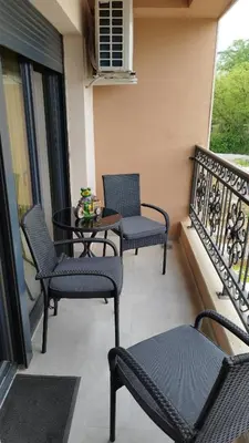 a balcony with three chairs and a table on a balcony at Apartman ARMANE 4 star LUX & Free EVcharge in Vrnjačka Banja