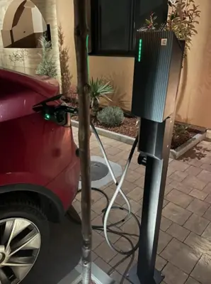 a solar powered car charger next to a car at Apartman ARMANE 4 star LUX & Free EVcharge in Vrnjačka Banja