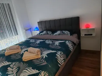 a bedroom with a bed with towels on it at Apartman ARMANE 4 star LUX & Free EVcharge in Vrnjačka Banja