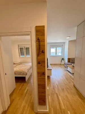 a room with a bed and a door to a bedroom at Tina Apartman Sokobanja in Soko Banja