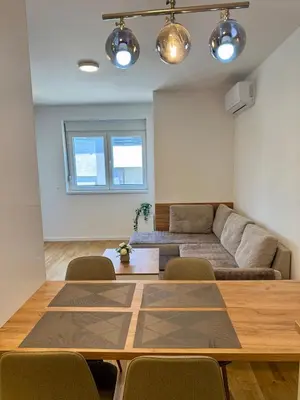 a living room with a table and a couch at Tina Apartman Sokobanja in Soko Banja