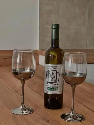 a bottle of wine and two wine glasses on a table at Tina Apartman Sokobanja in Soko Banja