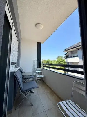 a balcony with a desk and a table and chairs at Tina Apartman Sokobanja in Soko Banja