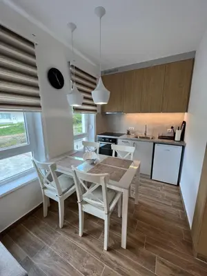 a kitchen and dining room with a table and chairs at Verde Apartman Sokobanja in Soko Banja
