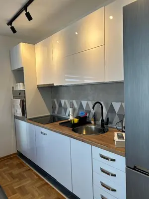 a kitchen with white cabinets and a sink at Sunset in Niš