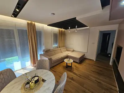 a living room with a couch and a table at PREMIUM APARTMAN ELENI ROOMS,oaza mira i tisine u centru Vrnjacke banje in Vrnjačka Banja