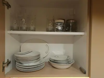 a shelf with plates and bowls in a cabinet at PREMIUM APARTMAN ELENI ROOMS,oaza mira i tisine u centru Vrnjacke banje in Vrnjačka Banja