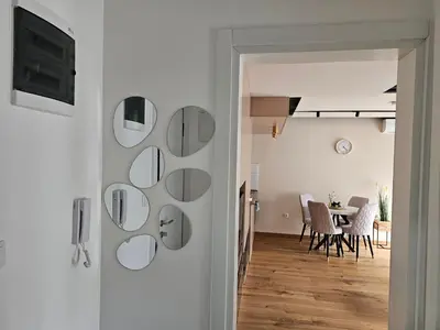 a room with white walls and a table with chairs at PREMIUM APARTMAN ELENI ROOMS,oaza mira i tisine u centru Vrnjacke banje in Vrnjačka Banja