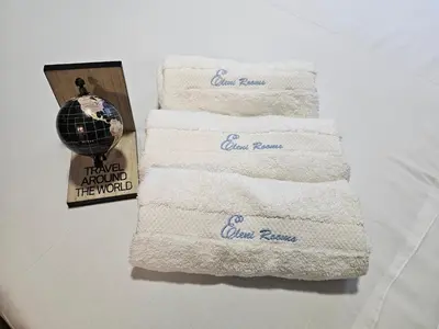 a stack of towels with a picture and a globe at PREMIUM APARTMAN ELENI ROOMS,oaza mira i tisine u centru Vrnjacke banje in Vrnjačka Banja
