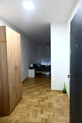 a room with a bed and a wooden floor at Riverside Nis in Niš