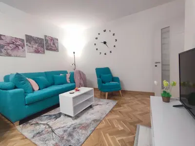 a living room with a blue couch and a tv at Apartman PINA Vrnjacka Banja in Vrnjačka Banja