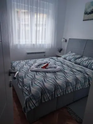 a room with a bed with a towel on it at Apartman PINA Vrnjacka Banja in Vrnjačka Banja