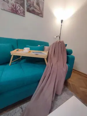 a living room with a blue couch with a table at Apartman PINA Vrnjacka Banja in Vrnjačka Banja