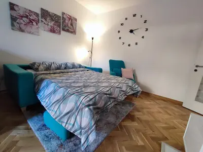 a bedroom with a bed and a clock on the wall at Apartman PINA Vrnjacka Banja in Vrnjačka Banja