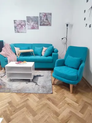 a living room with a blue couch and two chairs at Apartman PINA Vrnjacka Banja in Vrnjačka Banja