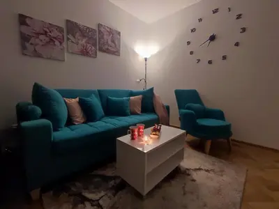 a living room with a blue couch and two chairs at Apartman PINA Vrnjacka Banja in Vrnjačka Banja