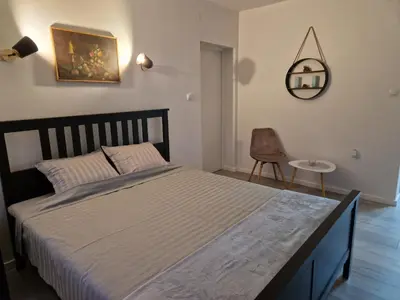 a bedroom with a bed and a chair and a mirror at Apartment F.R.I.E.N.D.S in Paraćin