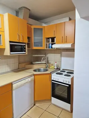 a kitchen with orange cabinets and a stove top oven at Apartment F.R.I.E.N.D.S in Paraćin