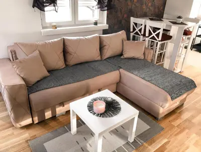 a brown couch in a living room with a table at BlueSky in Vrnjačka Banja