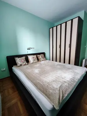 a bedroom with a large bed with blue walls at Apartman Leone Vrnjačka Banja in Vrnjačka Banja